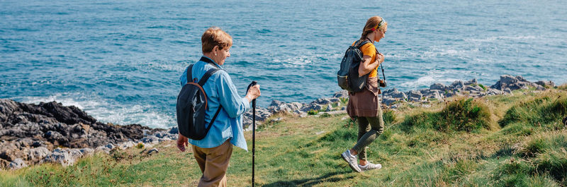 Grandmother and adult granddaughter trekking along the coast