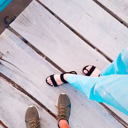 Low section of couple standing on wooden plank