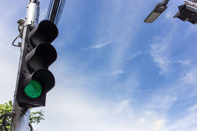 Low angle view of road signal against sky