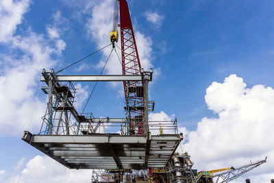 Offshore crane on board a construction work barge performing heavy lifting of a structure frame