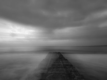 Scenic view of sea against storm clouds