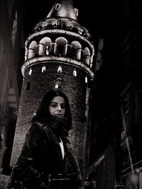 Low angle portrait of man against building at night