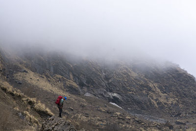 Full length of man on mountain during foggy weather