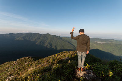 Man standing on mountain against clear blue sky