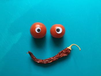 Anthropomorphic smiley face made from vegetable on turquoise table