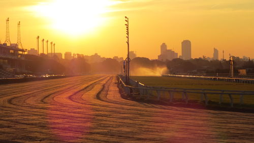 Horseracing track against sky during sunset