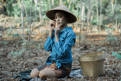 Full length of woman holding hat