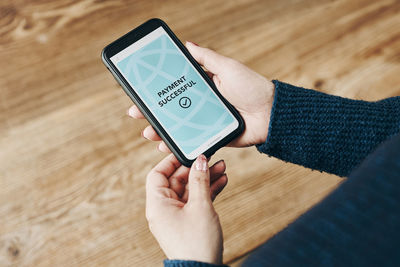 Cropped hands of woman using mobile phone
