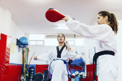 Instructor teaching martial arts to young woman