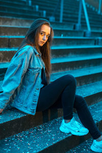 Portrait of young woman sitting on staircase