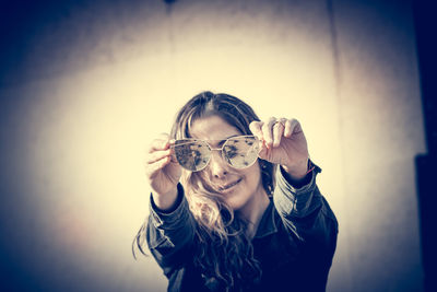 Portrait of a smiling young woman holding glass