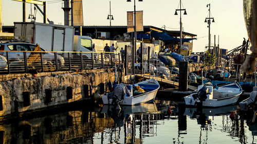 Boats moored at harbor against buildings in city