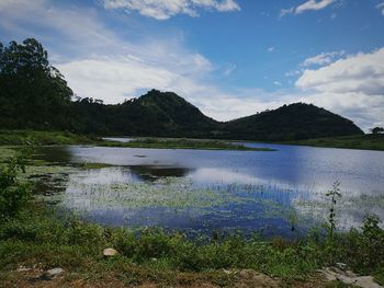 Scenic view of lake by mountains against sky