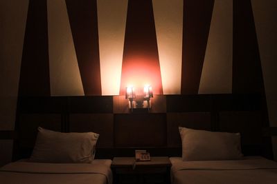 Illuminated electric lamp on bed at home