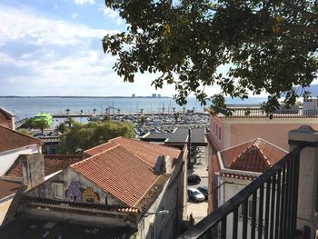 High angle view of townscape by sea against sky