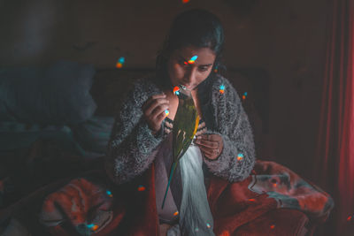 Young woman sitting on sofa at night