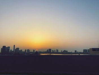 Silhouette buildings against sky during sunset