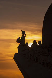 Low angle view of silhouette statue against sky during sunset