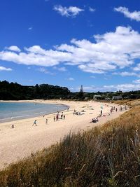 People on beach against blue sky