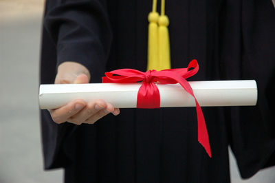 Midsection of man holding certificate