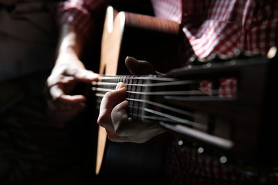 Midsection of person playing guitar