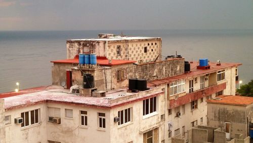 View of residential district by sea against sky