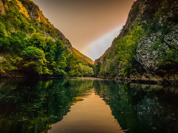 Scenic view of lake by trees against sky