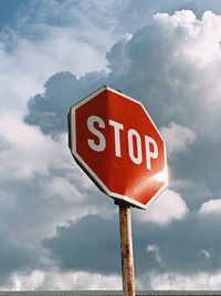 Low angle view of road sign against sky