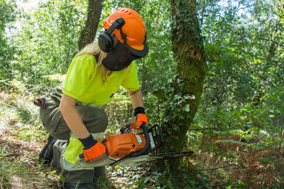 Forest worker working in the forest with the chainsaw