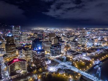 Illuminated cityscape against sky at night