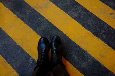 Low section of man standing on zebra crossing