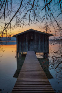 Pier over lake against sky during sunset