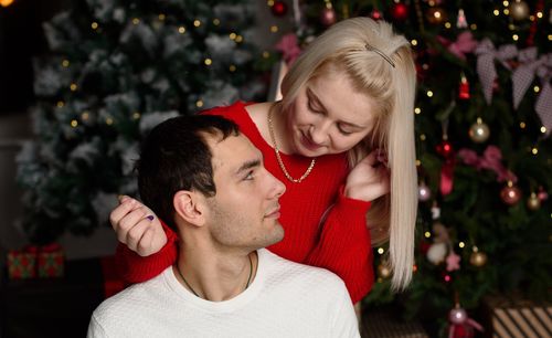 Rear view of man and woman with christmas tree