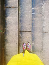 Low section of person standing against yellow wall