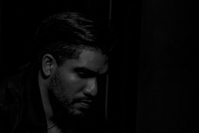 Close-up of man sitting in darkroom