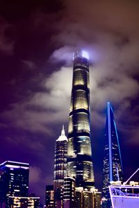 Low angle view of illuminated buildings against cloudy sky