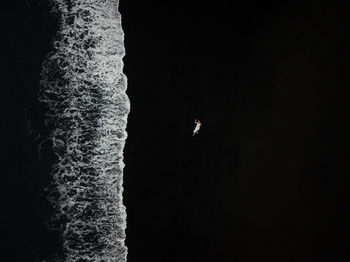 View from directly above woman lying  against black sand beach