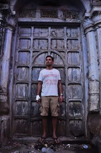 Full length of tourist standing against historic closed door