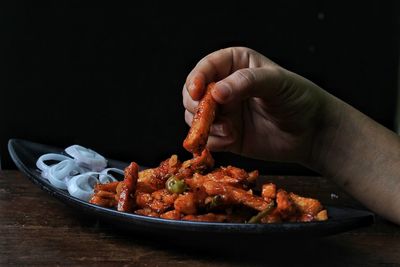 Person holding food on table