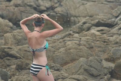 Rear view of young woman standing on rock