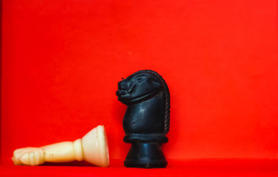 Close-up of chess pieces against red background