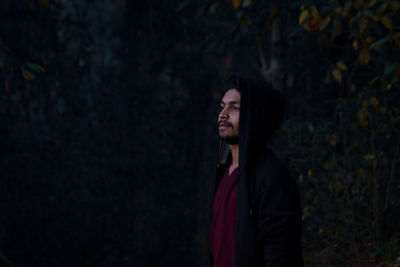 Young man looking away in forest