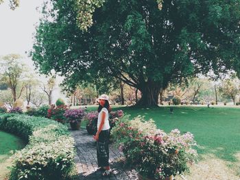 Woman standing by flowering tree in park