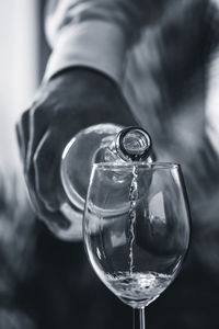 Cropped hand of bartendar pouring wine in glass