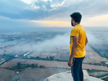 Rear view of man standing against sky