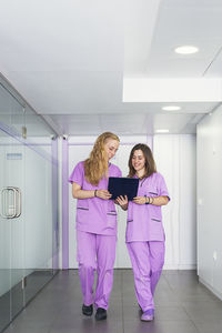 Full length of woman standing against purple wall