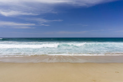 Scenic view of beach against blue sky