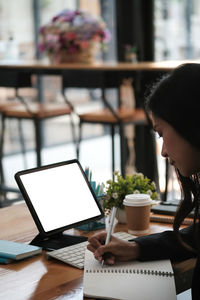 Woman working on computer at cafe