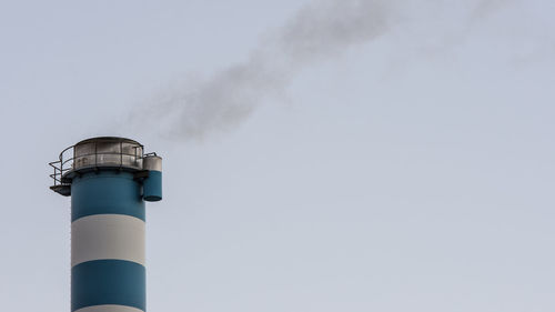 Low angle view of smoke stacks against sky