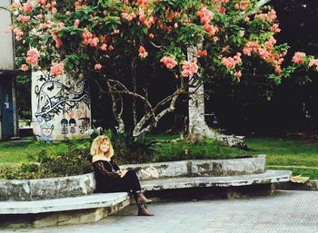 Woman sitting against trees